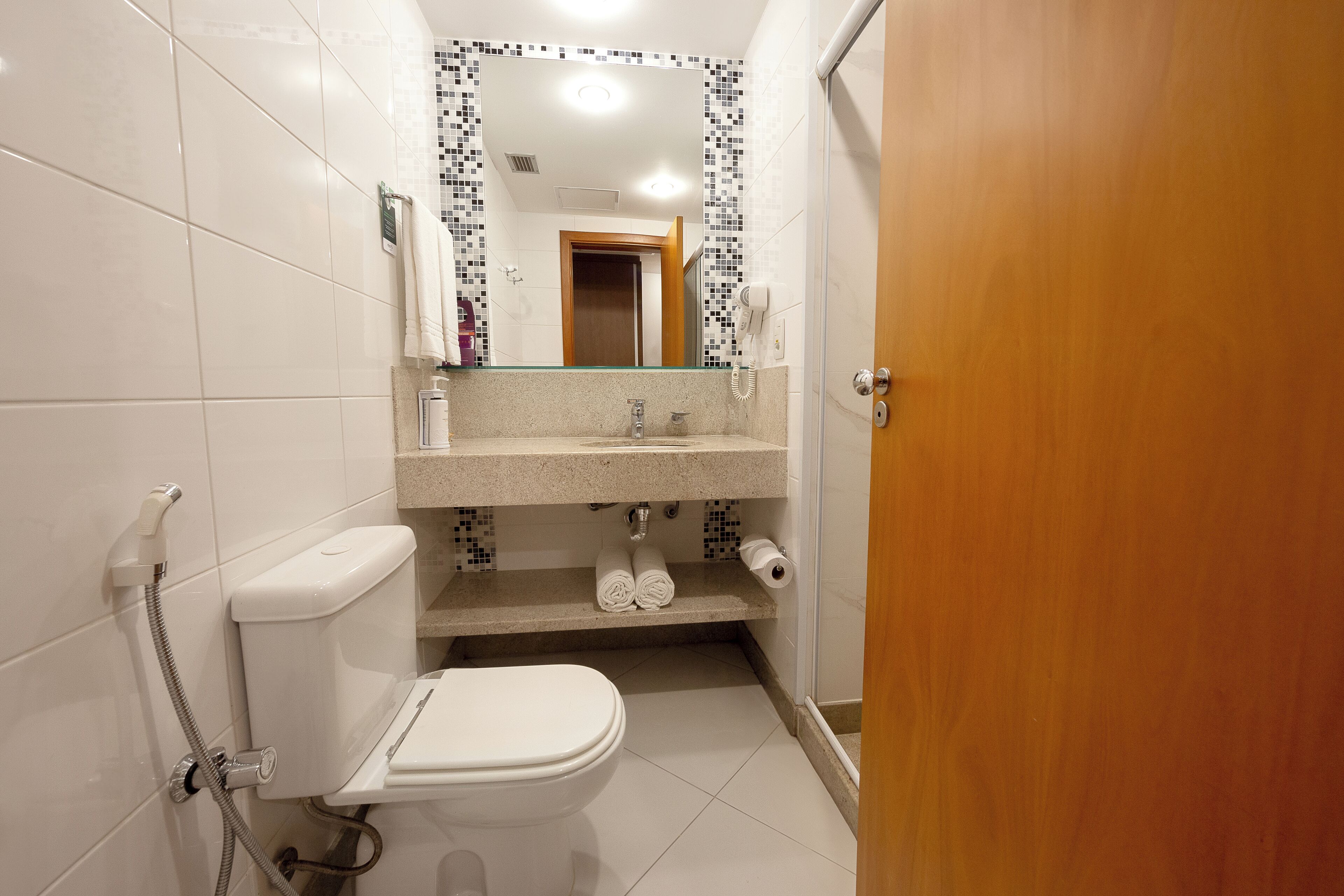 Un baño pequeño con inodoro, lavamanos y ducha.