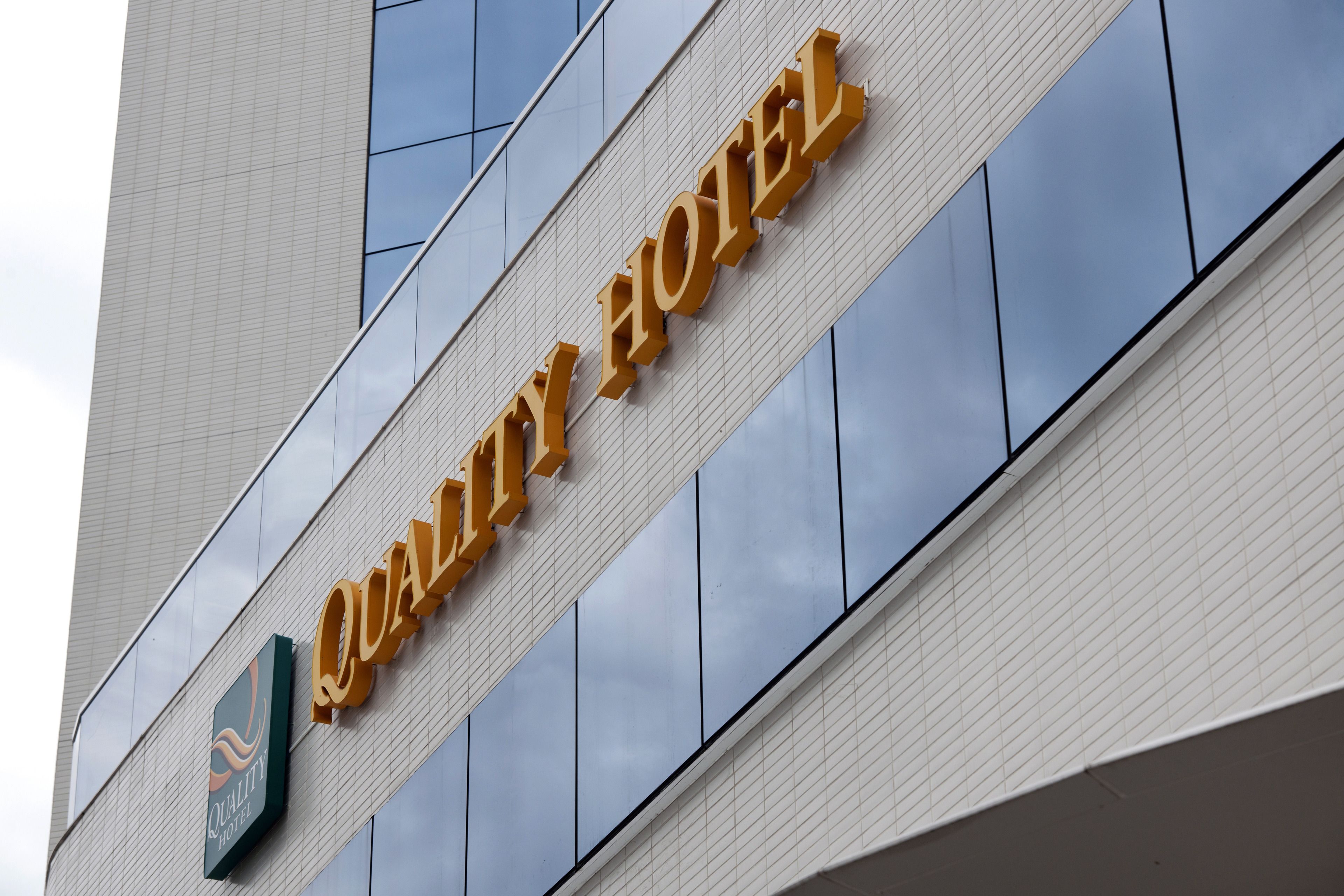 A hotel sign with the name "Quality Hotel" and a logo.