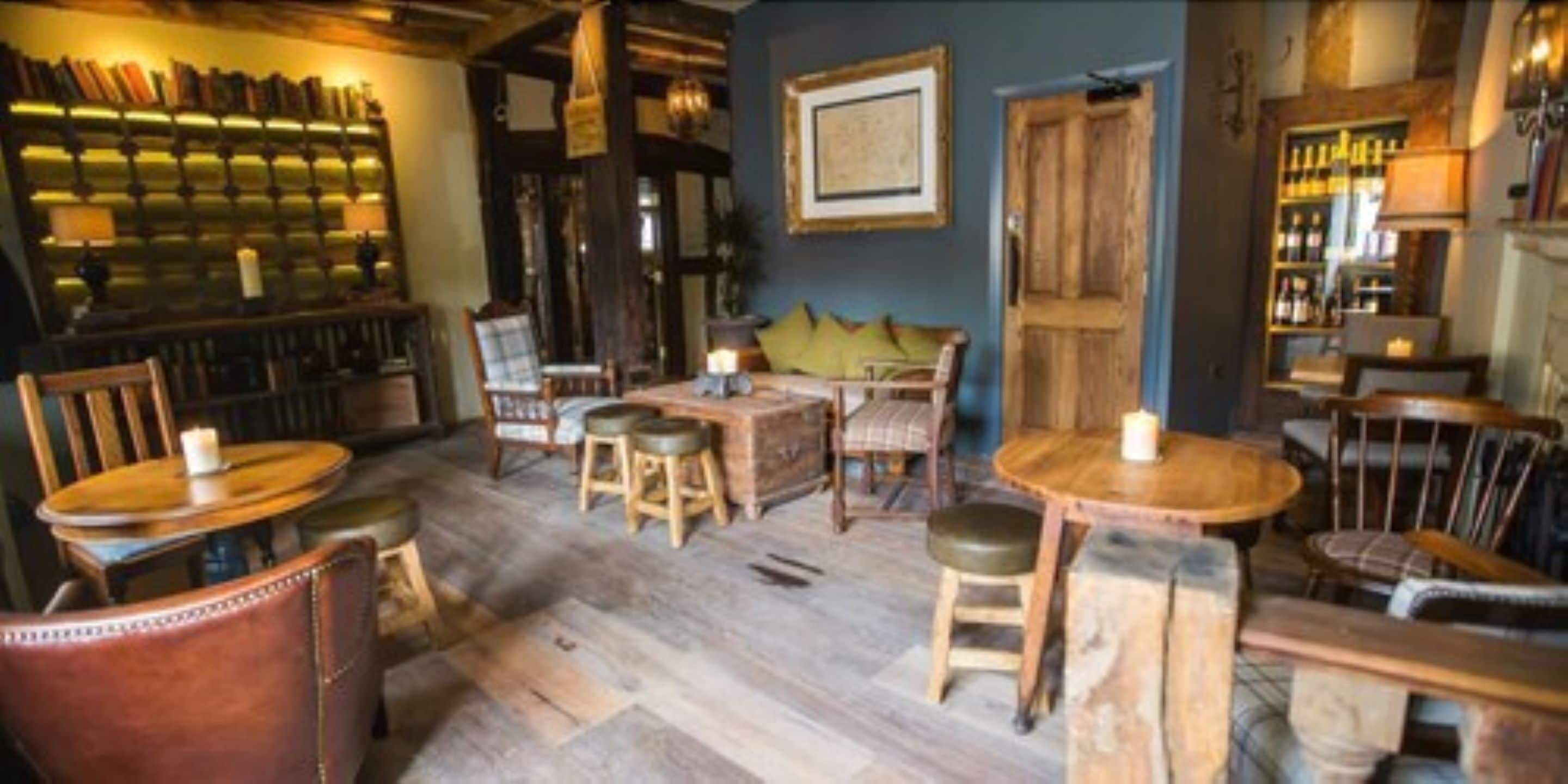 A cozy bar area with wooden furniture, a bookshelf, and a framed picture on the wall.