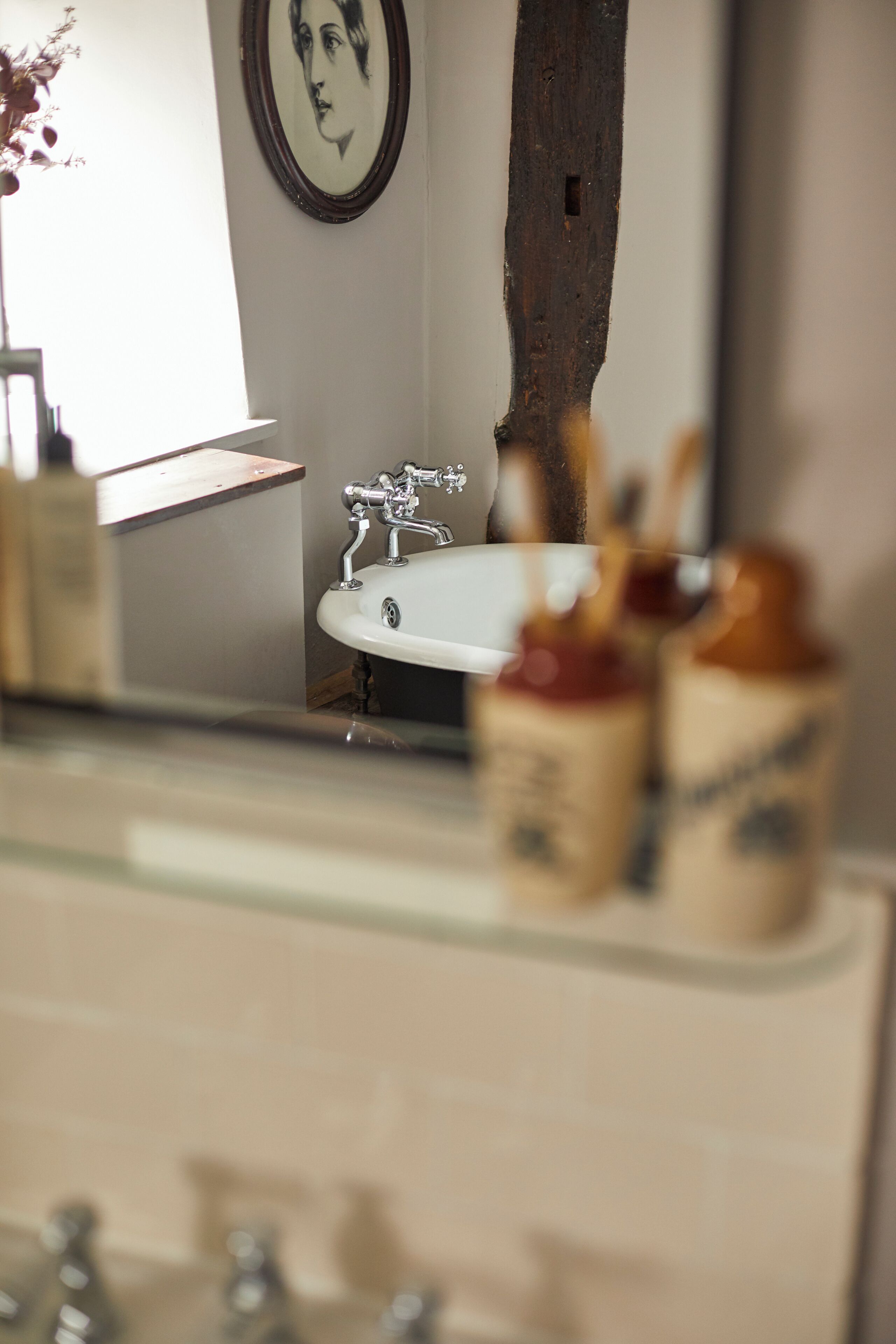 Une salle de bain avec un lavabo, un miroir et un mur en bois.