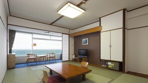 Une chambre d’hôtel avec une grande fenêtre, une table en bois, un téléviseur et un coffre-fort.
