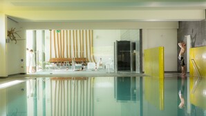 A swimming pool with clear water, a bench, and a changing room area. - Lifehouse Spa & Hotel (Clacton-on-Sea)