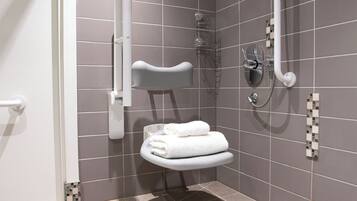 Un baño pequeño y moderno con ducha, inodoro y toallero.