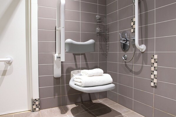 A small, modern bathroom with a shower, a toilet, and a towel rack. - Lifehouse Spa & Hotel (Clacton-on-Sea)