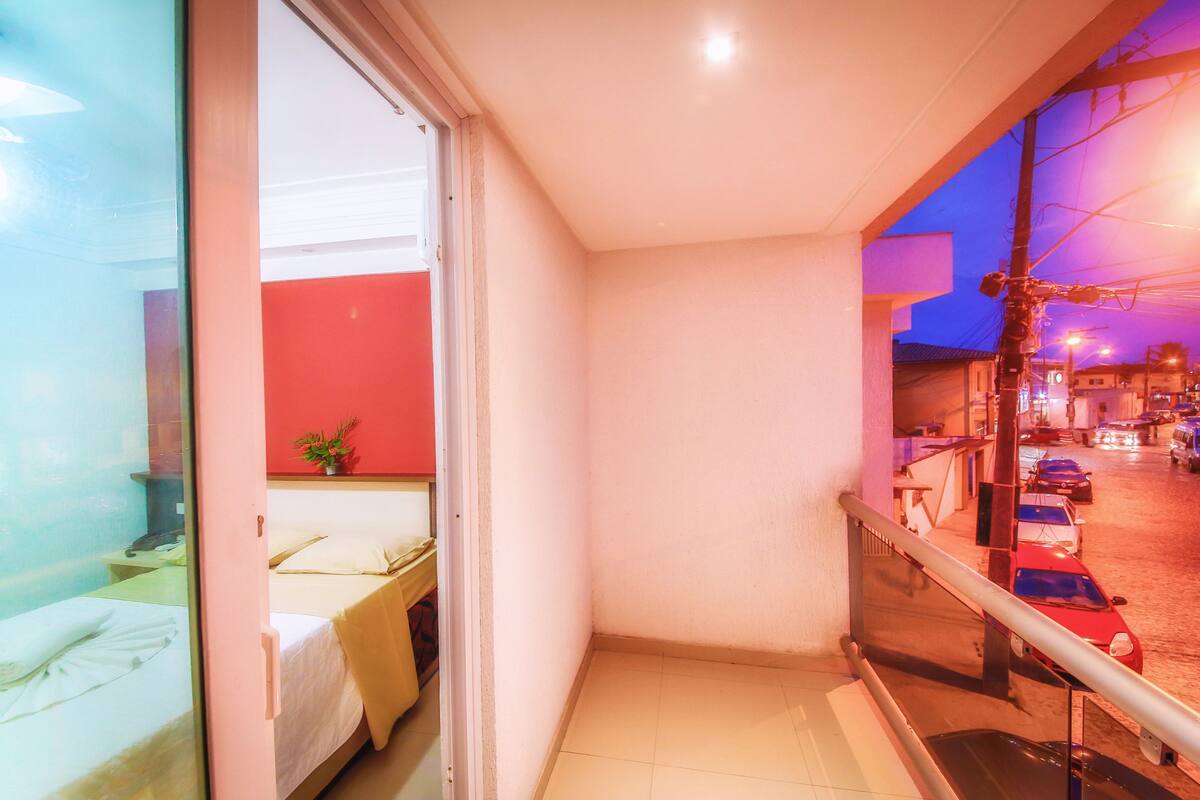 Ein Balkon mit Blick auf eine belebte Straße bei Nacht.