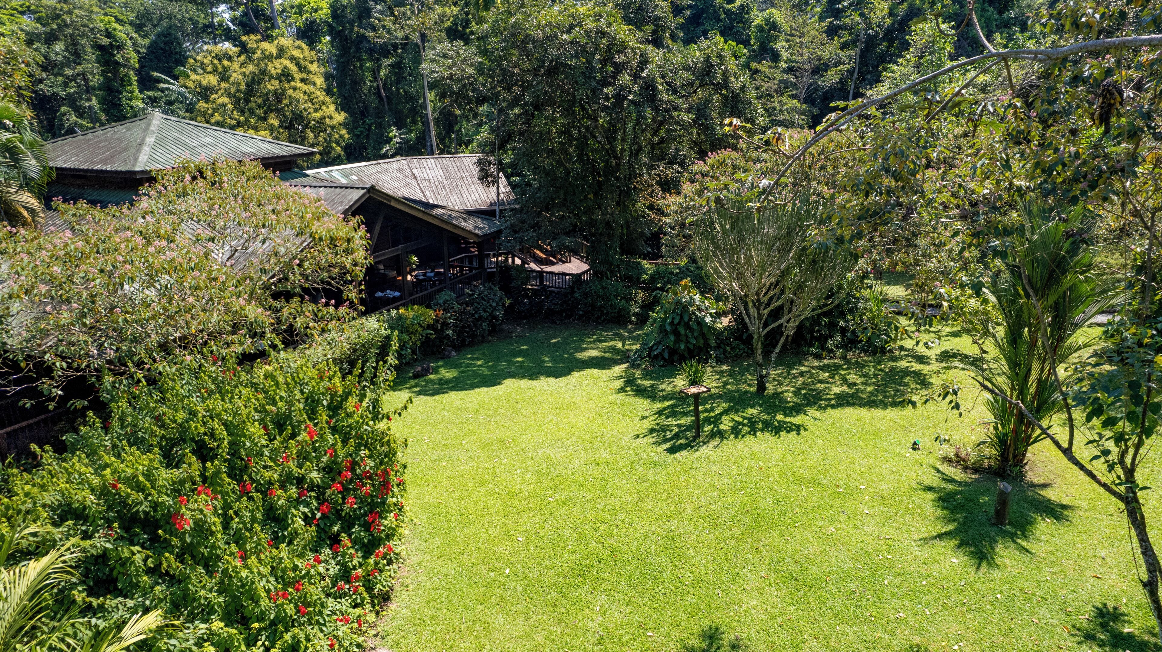 Un jardín bien cuidado con una casa de techo inclinado y un porche cubierto.
