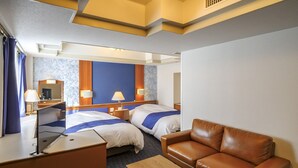 A hotel room with two beds, a leather sofa, a desk, and a small table. - Airline Hotel (Miyazaki)