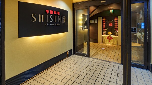 A hotel entrance with a sign reading "SHISEN Chinese table" and a traditional Chinese altar inside. - Airline Hotel (Miyazaki)