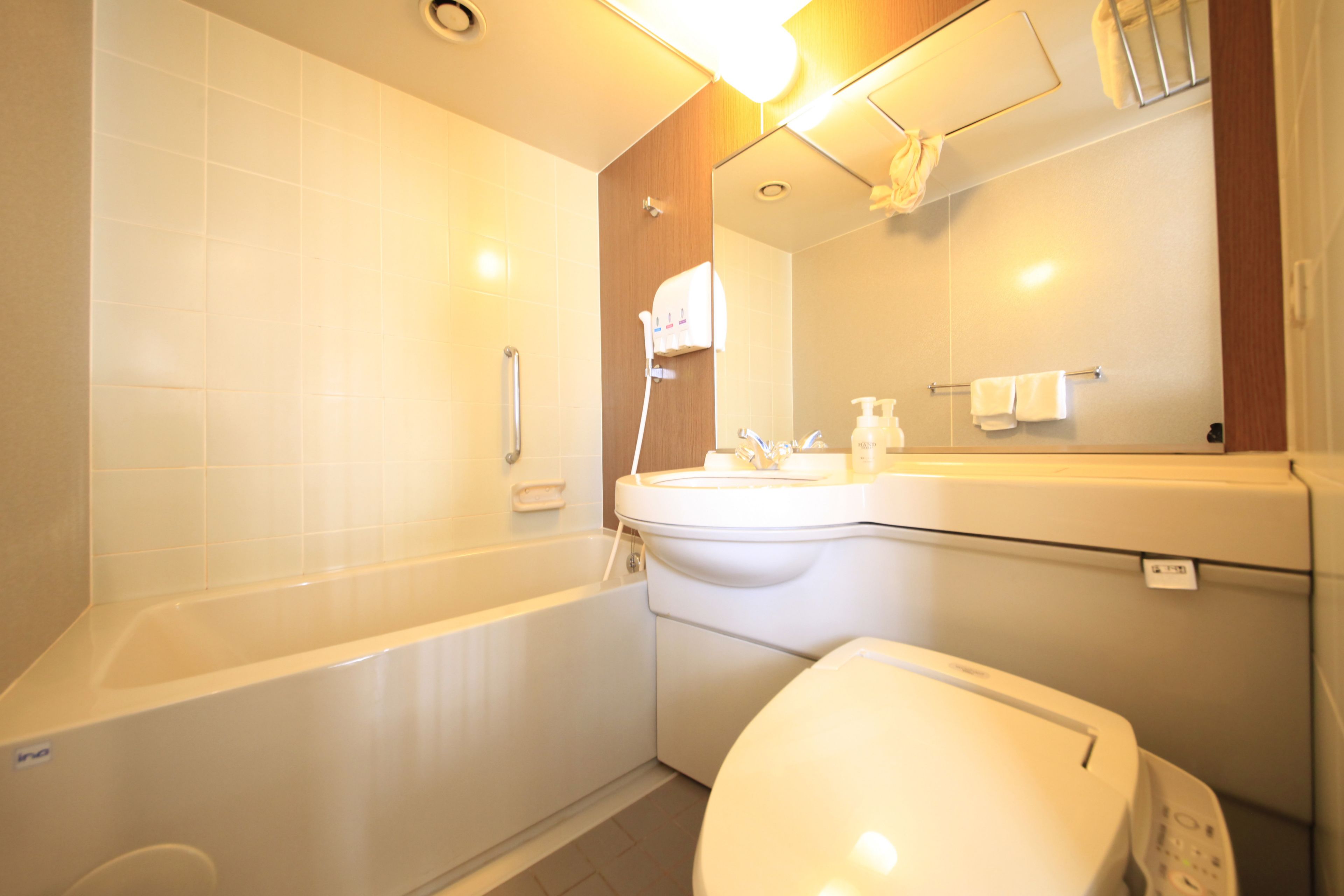 Un baño moderno con bañera, inodoro, lavabo y espejo sobre el lavabo.