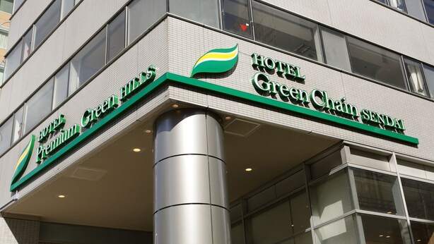The exterior of Hotel Green Chain Senda, featuring a modern design with a prominent green and yellow logo. - Hotel Premium Green Hills (Sendai)