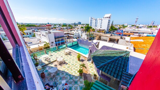 A rooftop pool area with a view of the cityscape, including a hotel and other buildings. - Hotel Ziami (Veracruz)