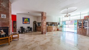 A spacious lobby with a marble floor, a reception desk, a dining area, and a view of the outside. - Hotel Ziami (Veracruz)