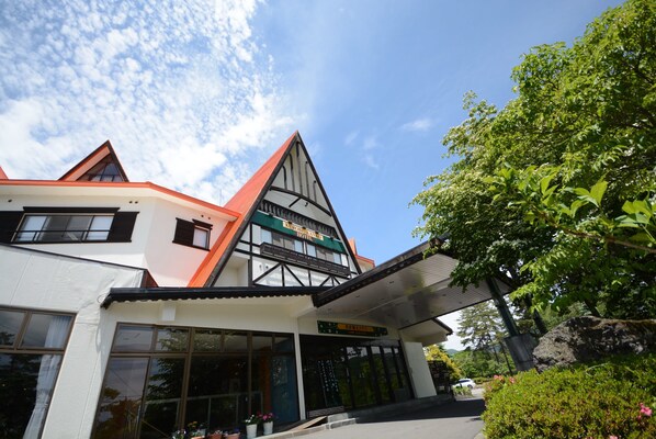 A hotel with a modern architectural design, featuring a prominent triangular roof and large windows. - Kurobe Kanko Hotel (Omachi)