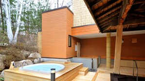 A modern spa with a wooden deck, a hot tub, and a wooden sauna. - Kurobe Kanko Hotel (Omachi)