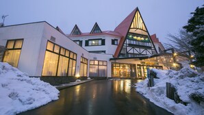 A hotel with a modern architectural design, featuring a prominent triangular roof and large windows. - Kurobe Kanko Hotel (Omachi)