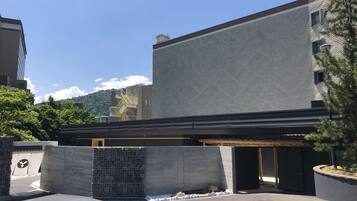 Un edificio moderno con tejado plano, amplia fachada de vidrio y una entrada pequeña.