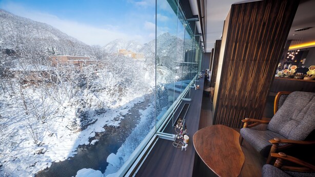 A modern interior with a large window overlooking a snowy landscape.