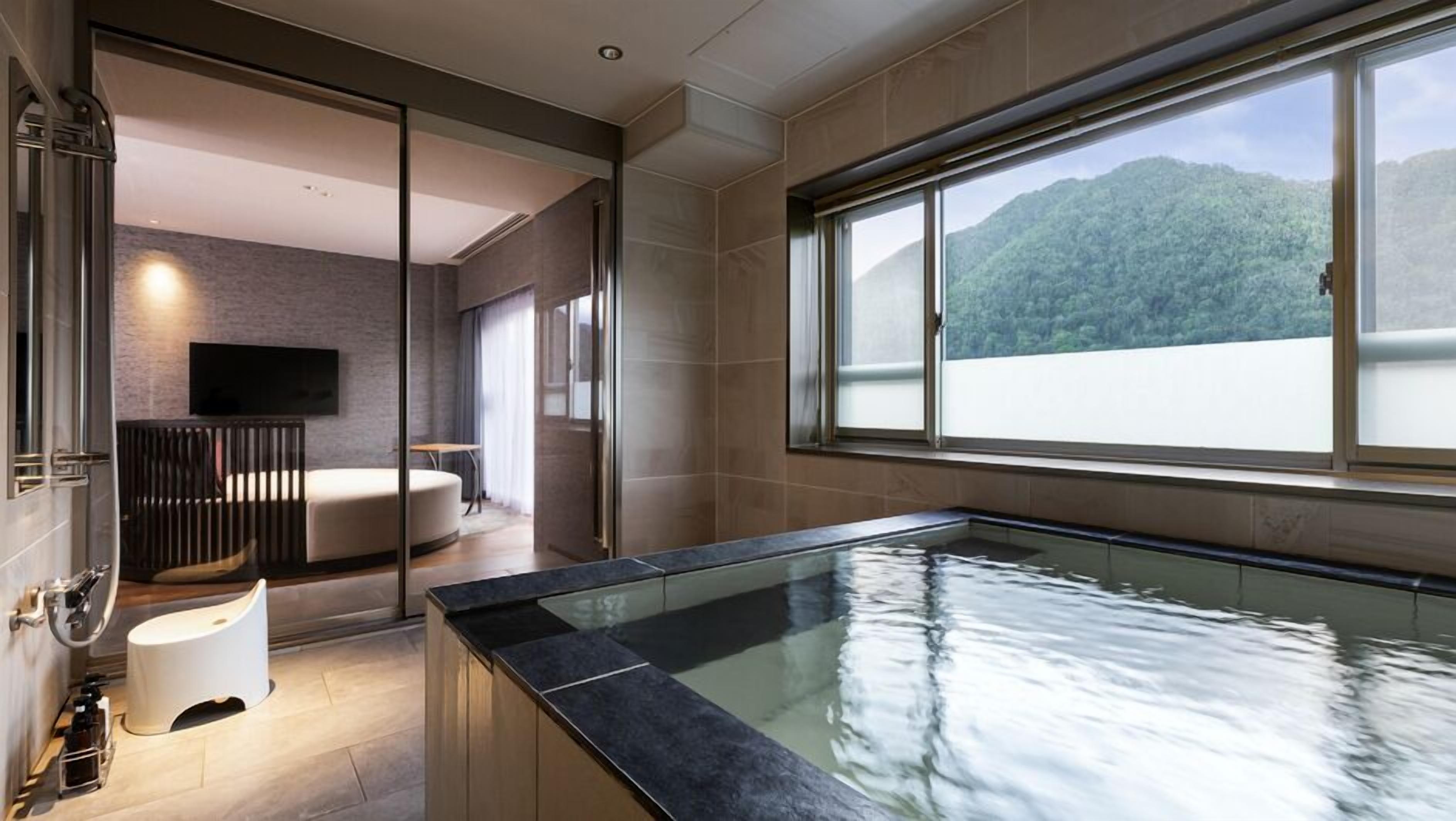 A modern bathroom with a bathtub, a toilet, and a shower area.