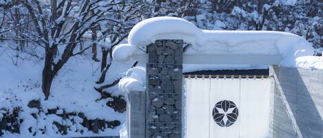 A stone wall with a snow-covered gate and a circular emblem.