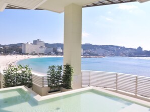 A pool area with a view of a beach and cityscape. - Shiraraso Grand Hotel (Shirahama)