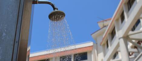 A showerhead with water flowing into the air.