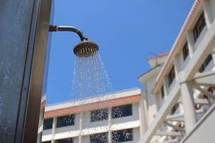 Un cabezal de ducha con agua fluyendo al aire.