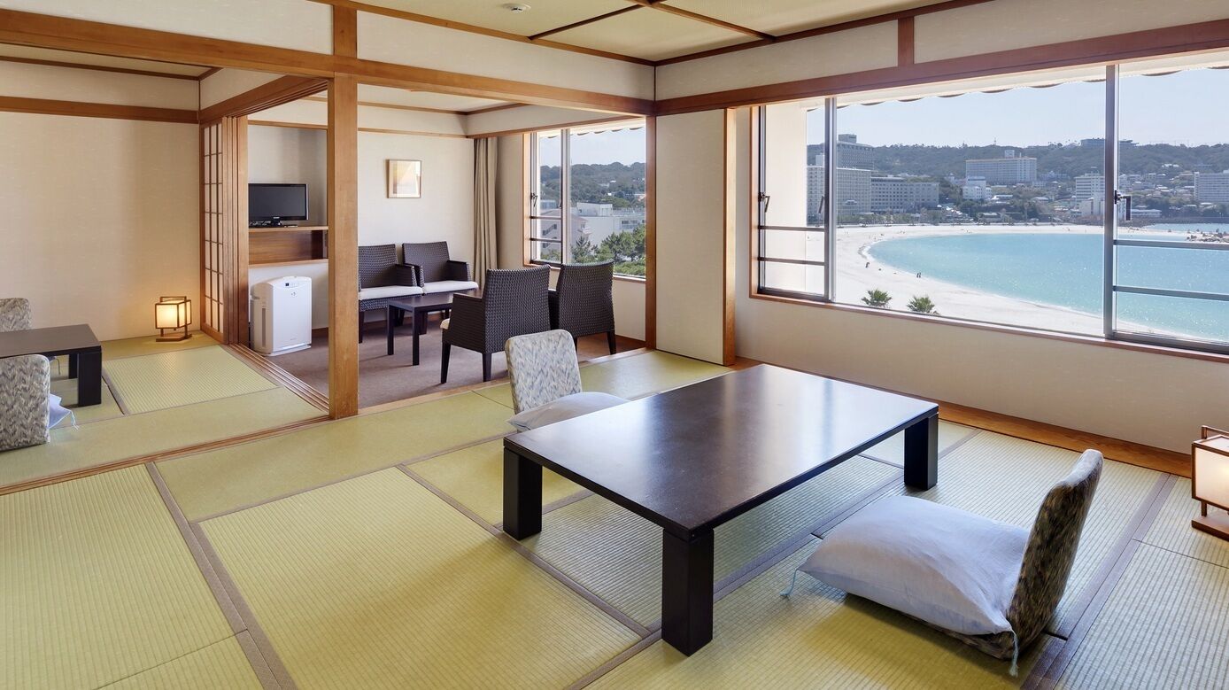 Une pièce de style japonais traditionnel, avec un sol recouvert de tatamis, une table basse et des chaises.