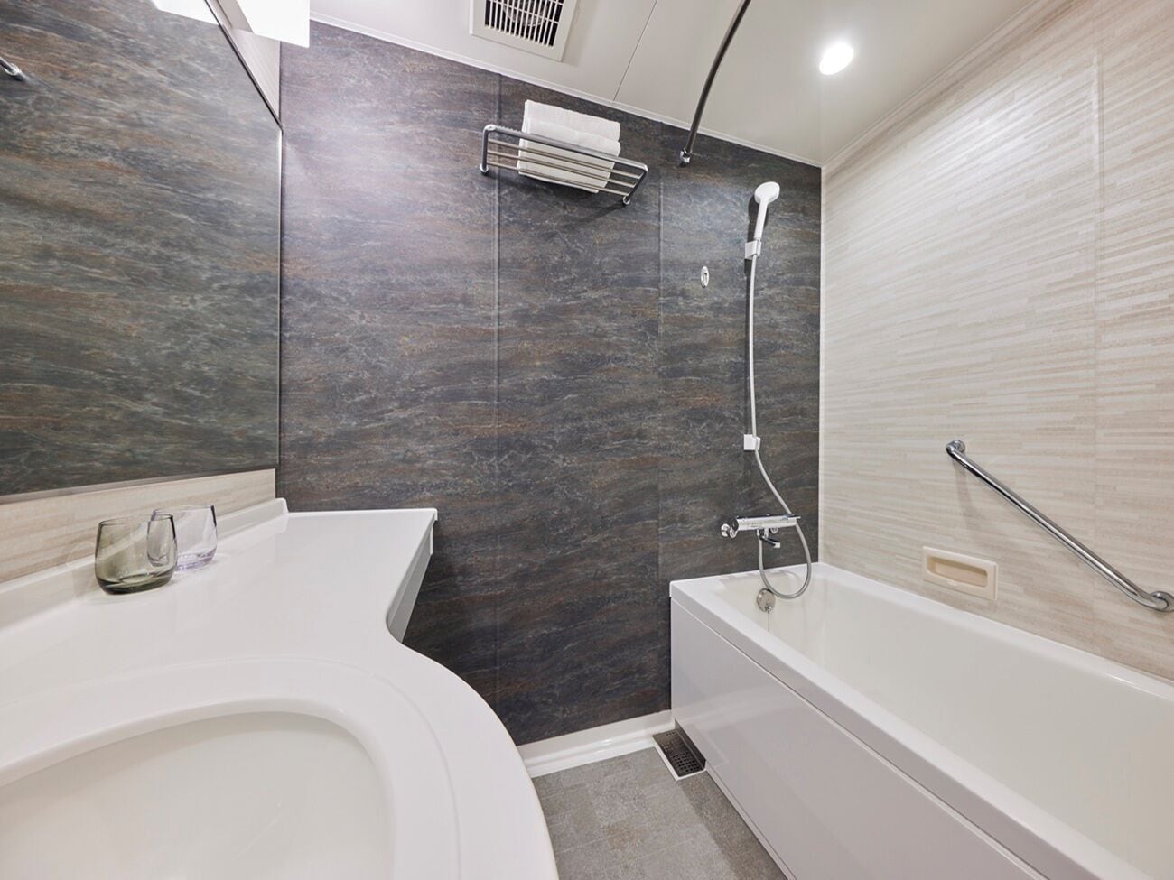 Une salle de bain moderne équipée de toilettes, d’une baignoire et d’une douche.
