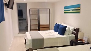 A hotel room with two beds, a TV, a painting, and a bathroom with a shower and toilet. - Pousada Estrela do Mar (Salvador)