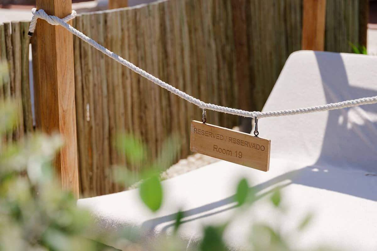 A rope barrier with a sign indicating 'RESERVED / RESERVADO Room 19'.