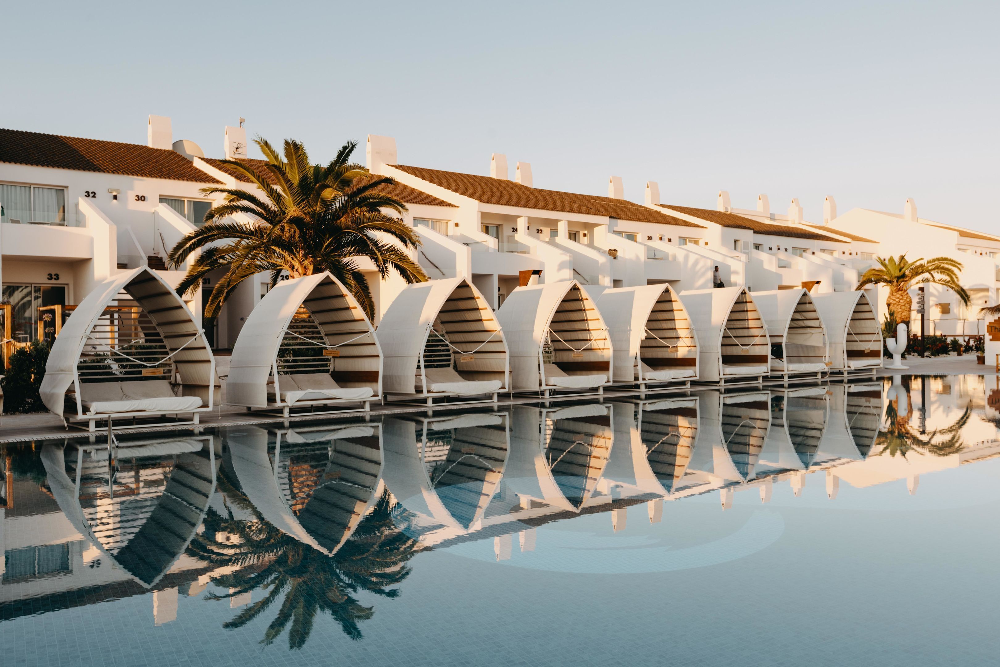 Un hotel moderno con piscina que refleja su arquitectura.