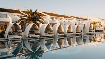 Un hotel moderno con piscina que refleja su arquitectura.