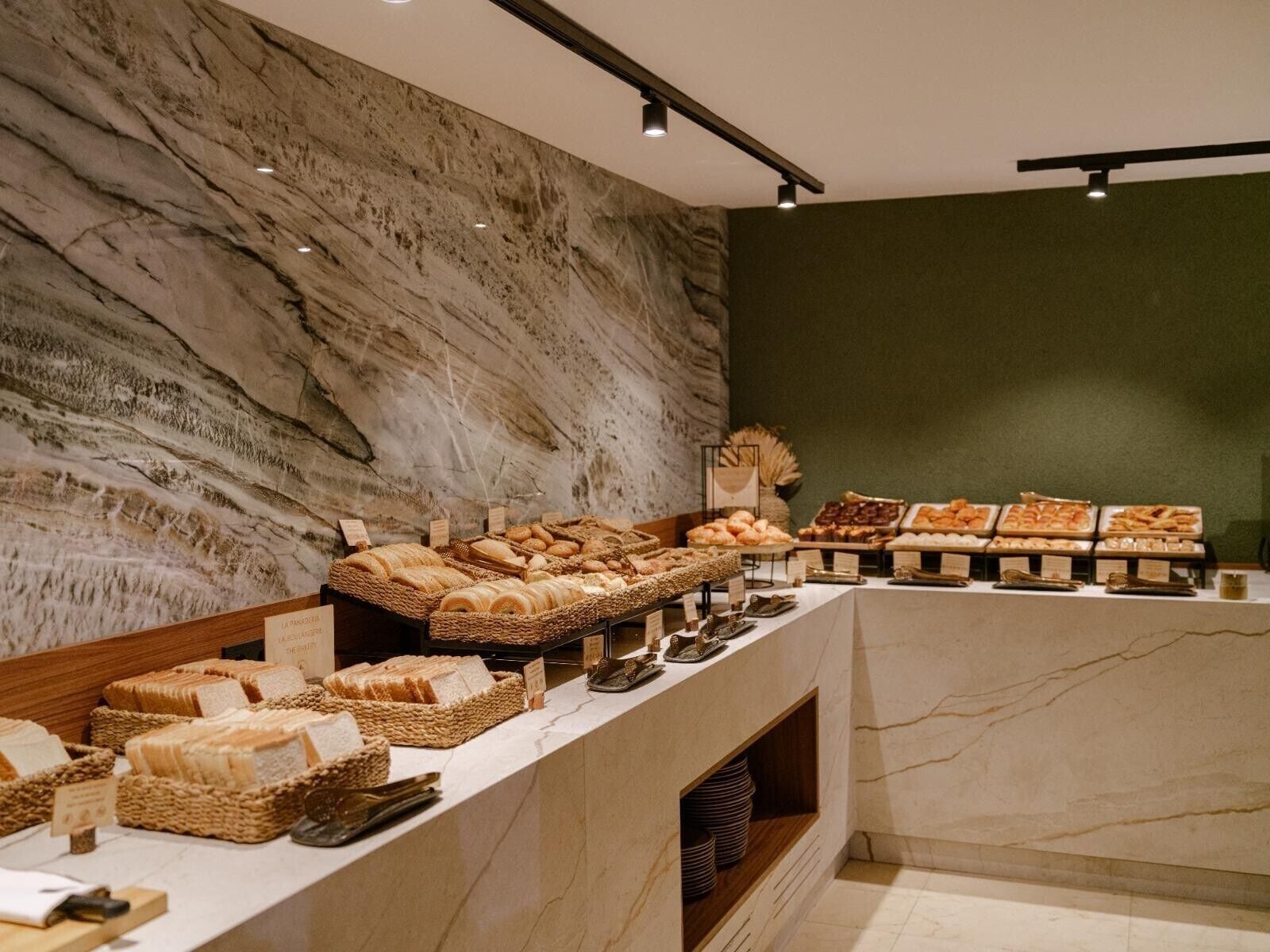 A bakery display with various breads and pastries.