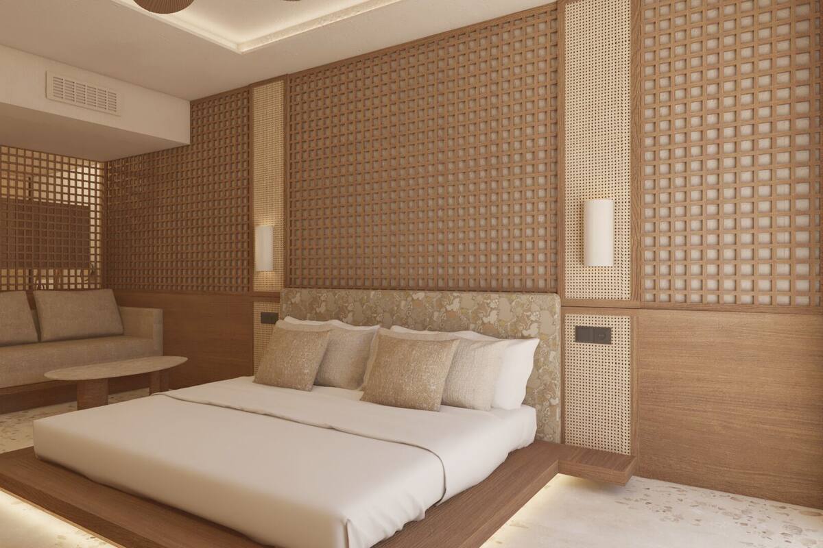 A modern bedroom with a large bed, a sofa, and a small table.