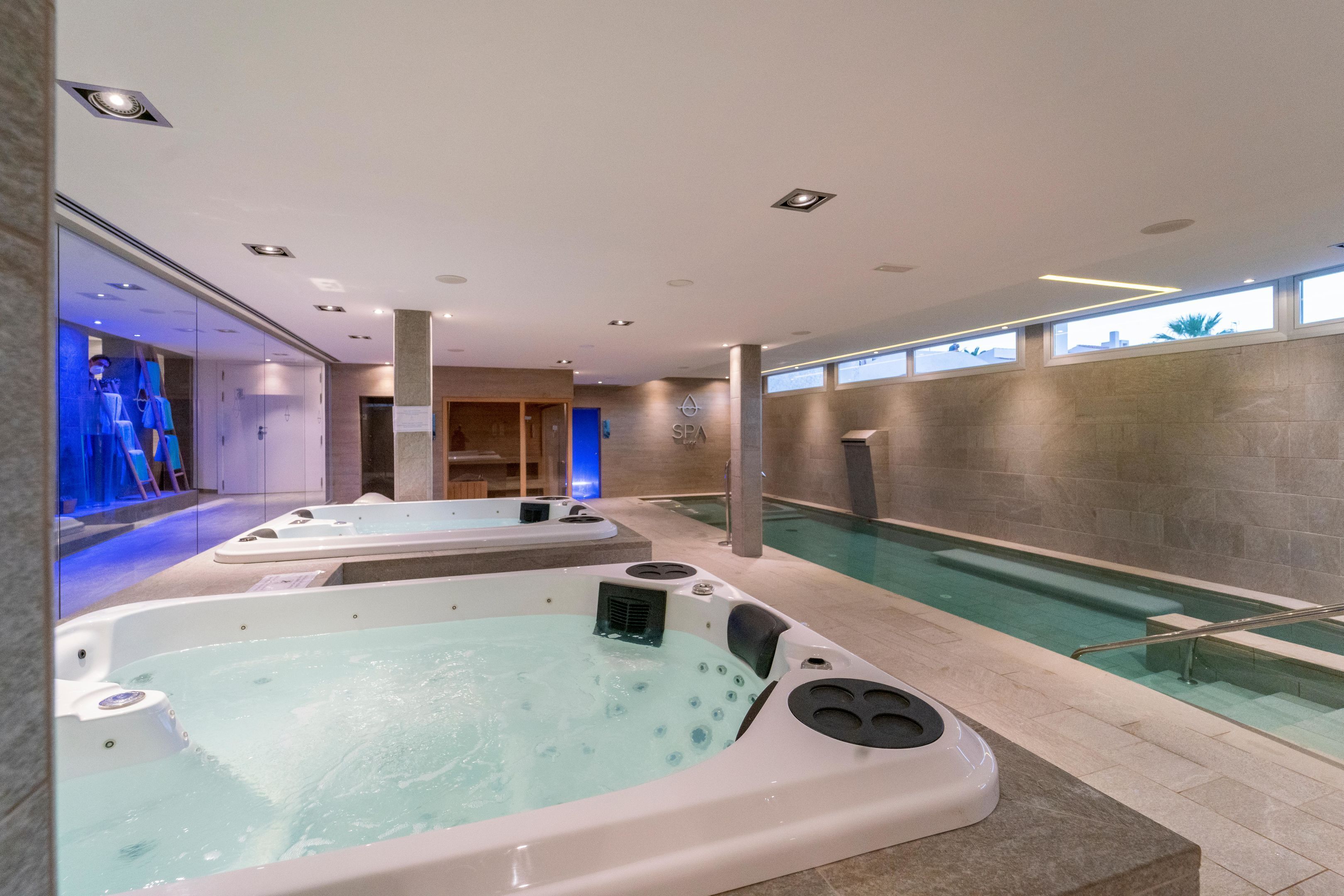 A spa area with two hot tubs and a pool.