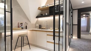 A modern kitchen with a bar stool, a microwave, and a sink. - Pensjonat Tatry (Koscielisko)