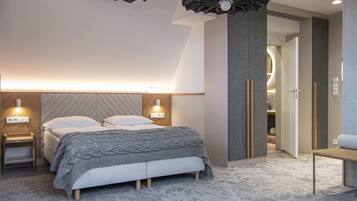 Quarto moderno com uma cama grande, mesas de cabeceira e uma luminária de teto singular.