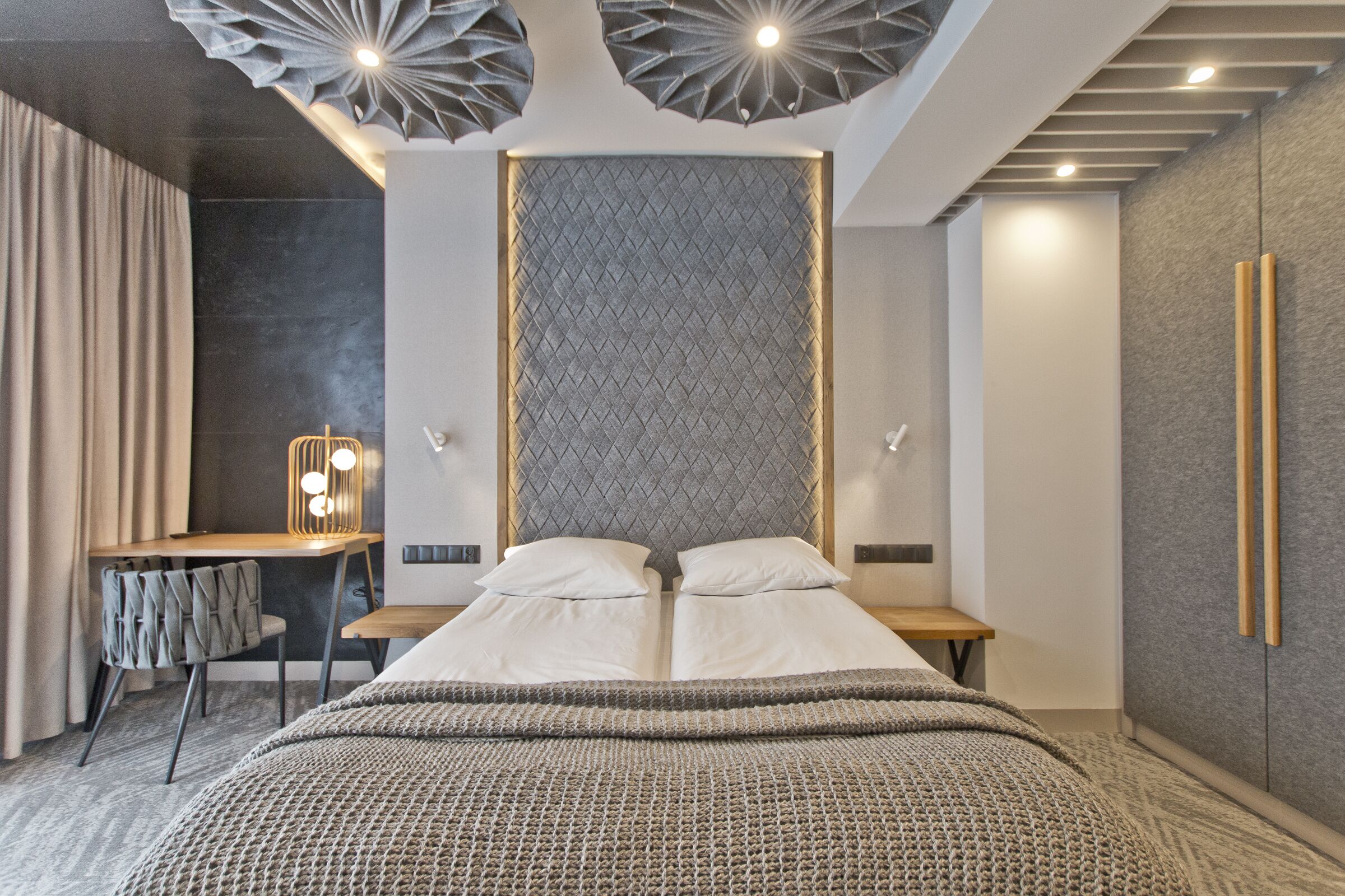 Un dormitorio moderno con una cama grande, un escritorio y una silla.