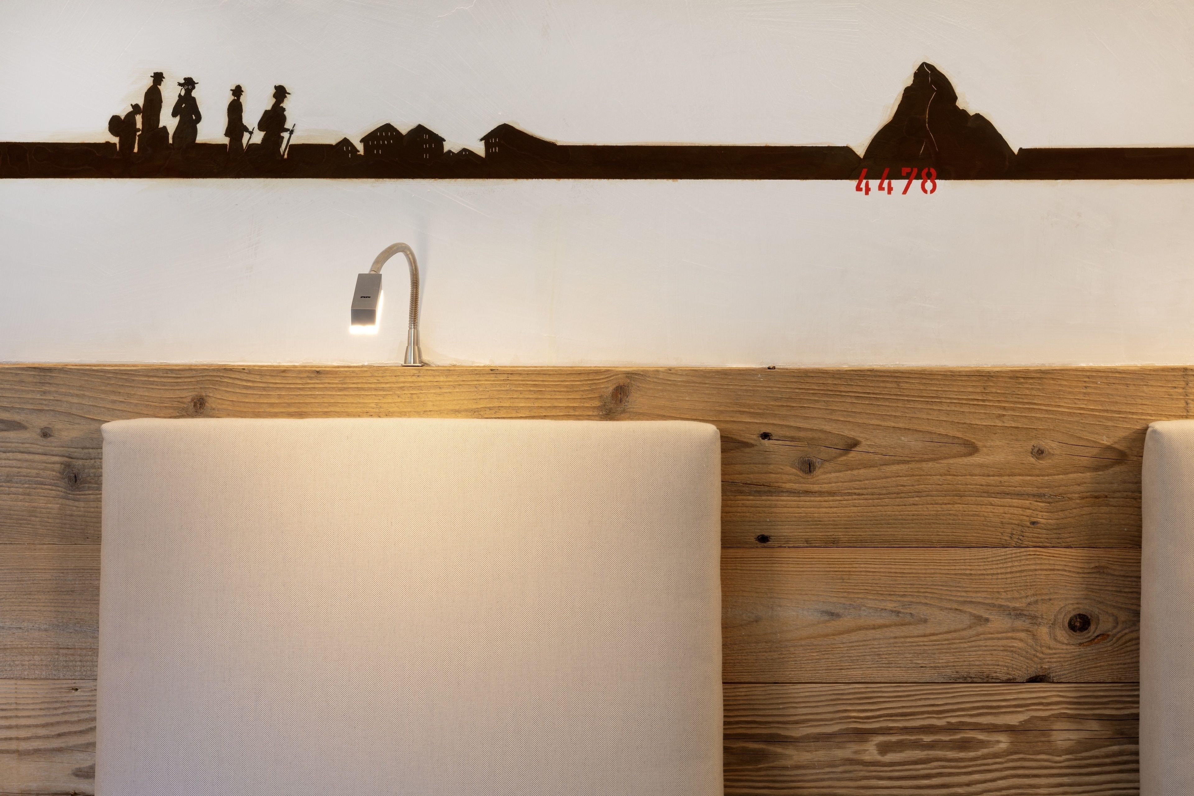 Ein Badezimmer mit Holzwand, Waschbecken und einer Silhouettenmalerei über dem Spiegel.