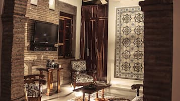 Uma sala de estar aconchegante com lareira, móveis de madeira e um tapete estampado.