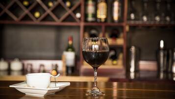 A bar setting with a wine glass and a teacup on a wooden table.