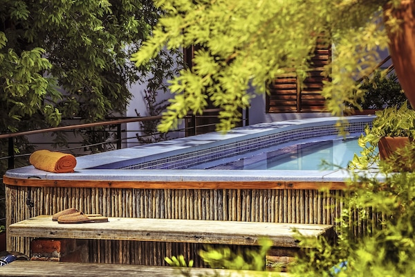 Una piscina al aire libre, sillones reclinables de piscina