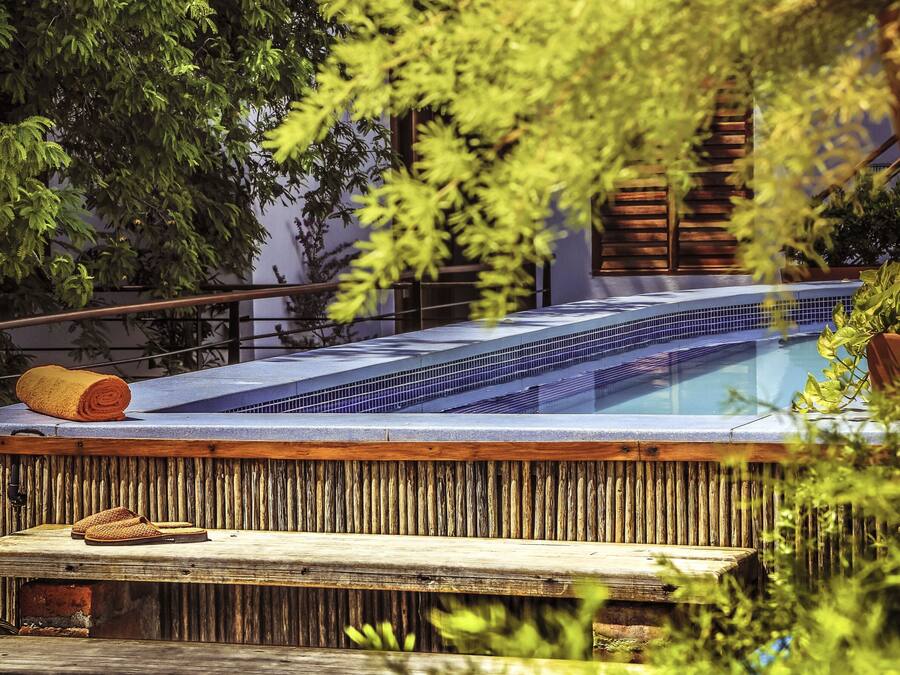 Una piscina al aire libre, sillones reclinables de piscina