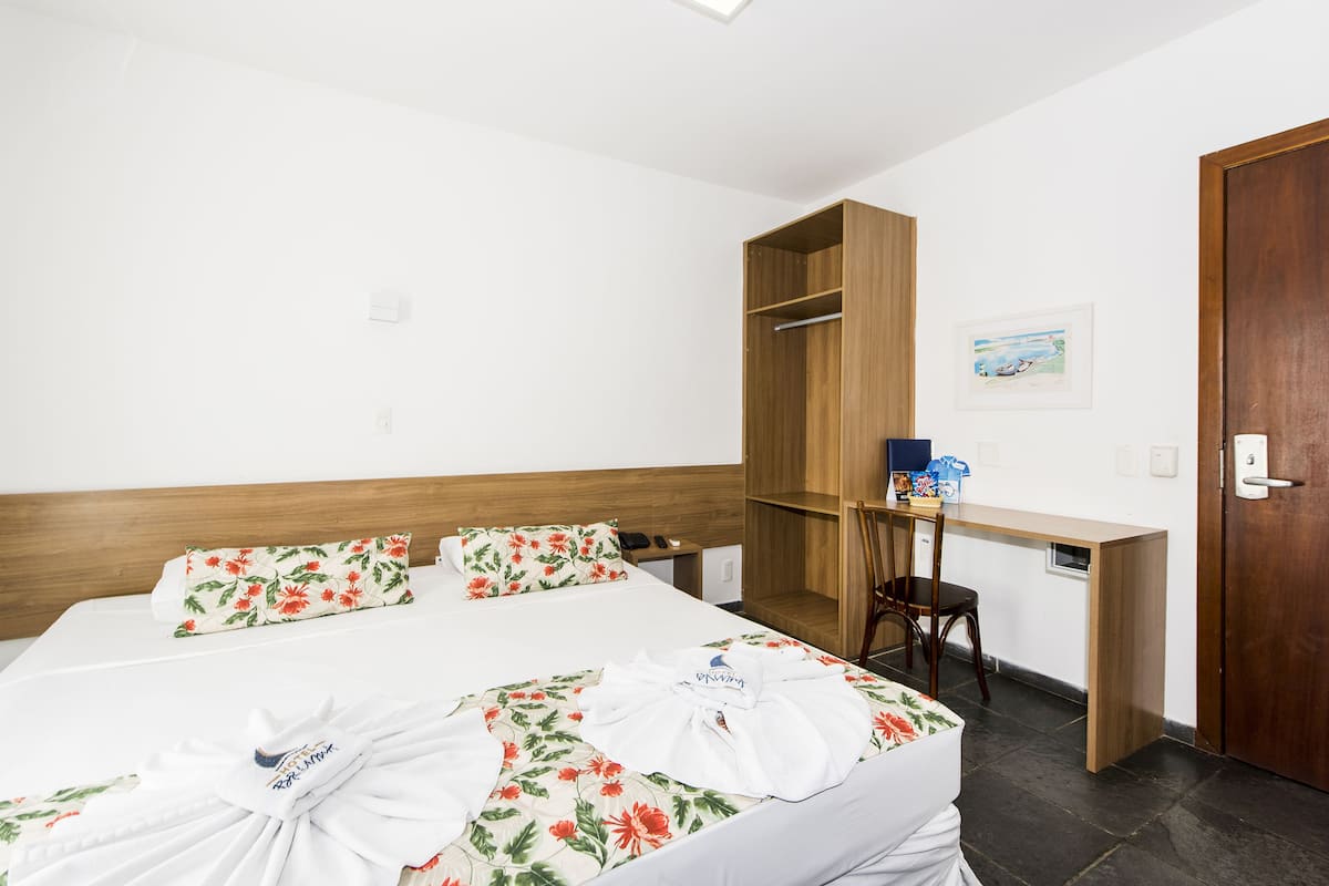 Une chambre d’hôtel avec un lit, un bureau et une armoire.