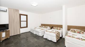 Una habitación de hotel con dos camas individuales, televisión y ventana con cortinas.