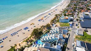 Vista aérea de una ciudad costera con playa, edificios de hotel y piscina.