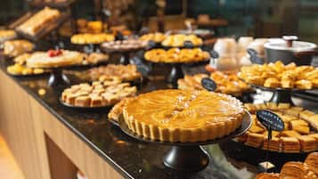 Um buffet com diversos doces e pâtisseries.