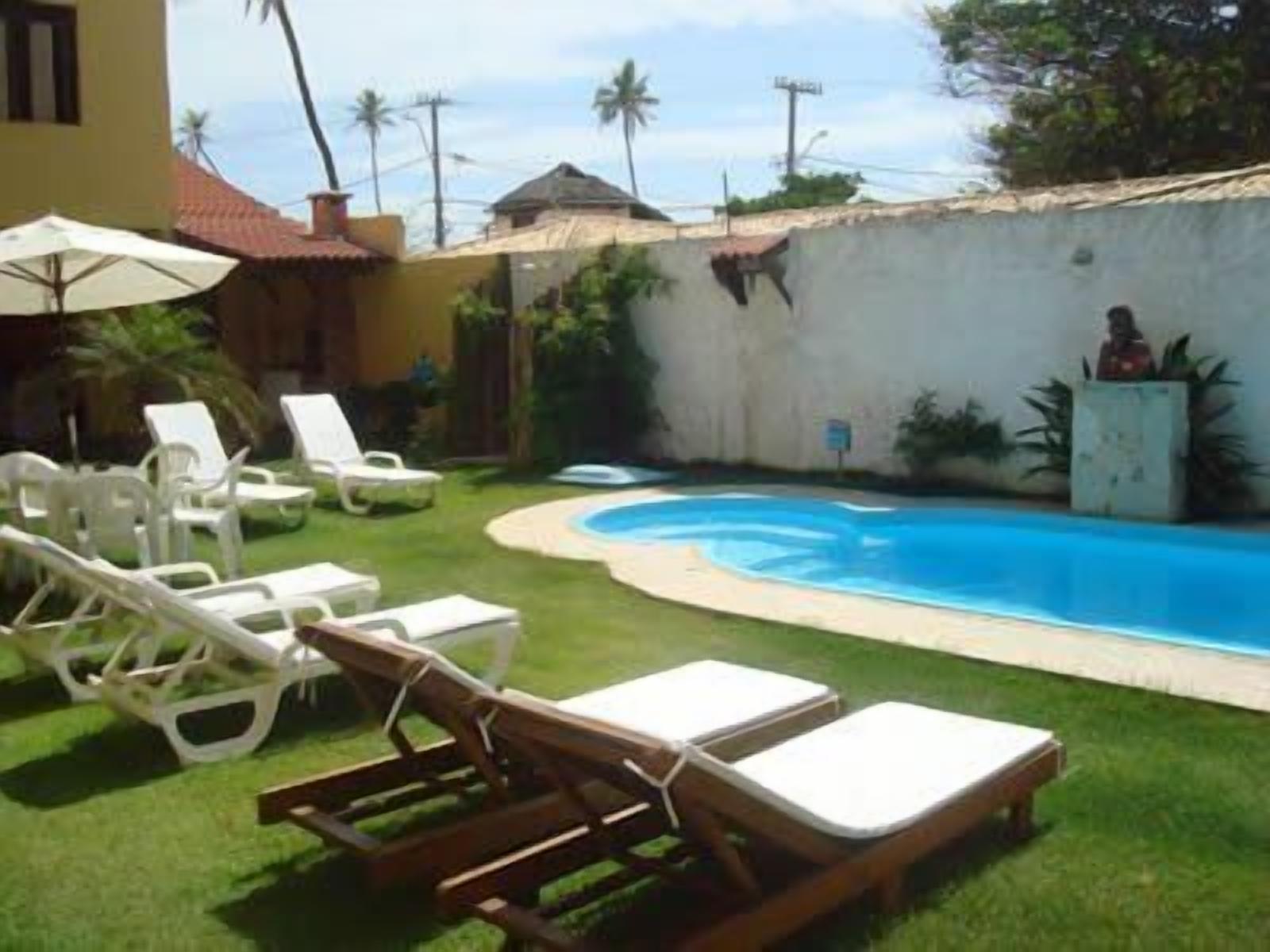 Uma área de piscina com espreguiçadeiras e uma piscina pequena.
