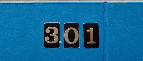 A house number '301' on a blue and white wall.