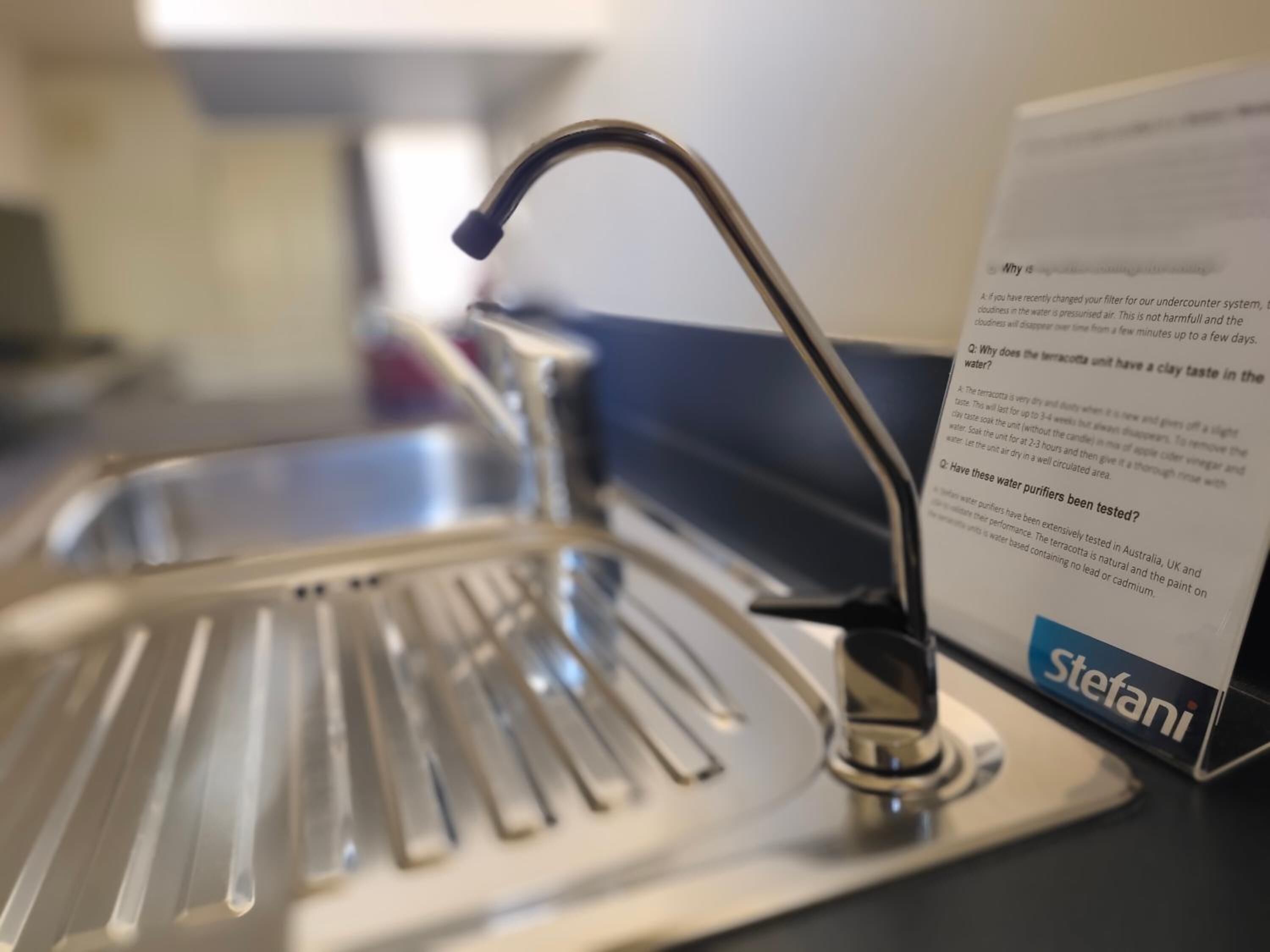 Een keukenkraan met een moderne kraan en een waterfilterapparaat met de tekst 'Stefani'.